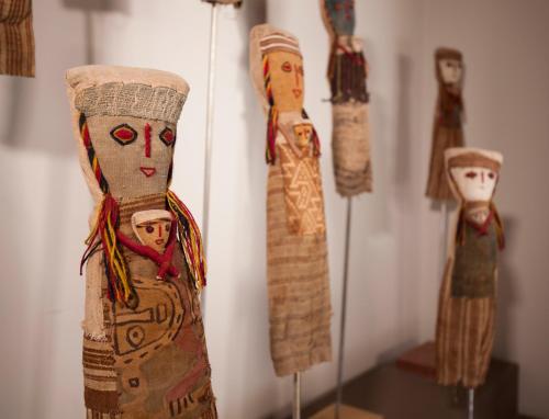 a group of wooden dolls on display in a museum at Hotel Huacalera in Huacalera