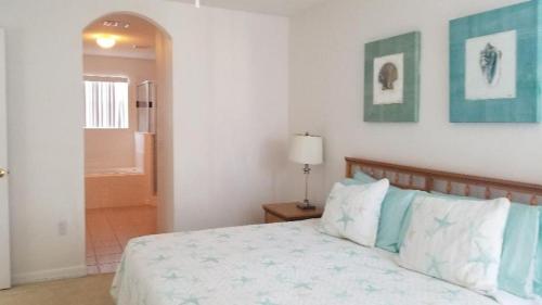 a bedroom with a bed with blue and white pillows at Kissimmee in Kissimmee