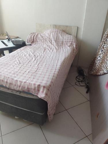 ブラジリアにあるQuarto individual com cama cama de casalのベッドルーム1室(ピンクの毛布付きのベッド1台付)