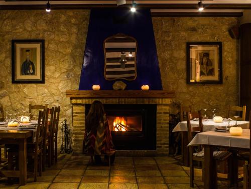 a woman standing in front of a fireplace in a restaurant at La Font D'Alcala in Alcalá de la Jovada