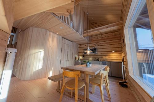 una sala da pranzo con tavolo e sedie in legno di Handcrafted Log Chalet Villa Aarreaitta a Pudasjärvi