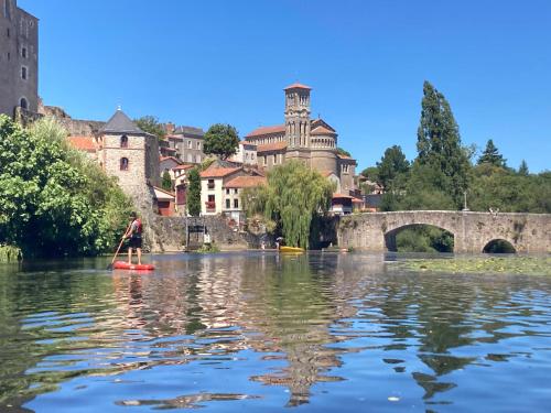 a person on a paddle board on a river in a city at Hellfest 2025 chambre petit-déjeuner in La Celle-sous-Gouzon