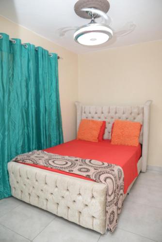 a bedroom with a large bed with green curtains at Amplio apartamento 3 abitaciones ideal para familia in Santiago de los Caballeros