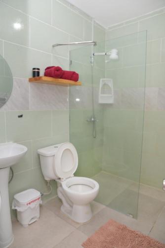 a bathroom with a toilet and a glass shower at Amplio apartamento 3 abitaciones ideal para familia in Santiago de los Caballeros