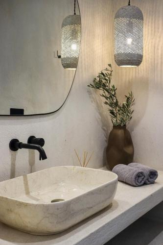 a bathroom with a stone sink and two lights at Vabel Skiathos in Skiathos Town