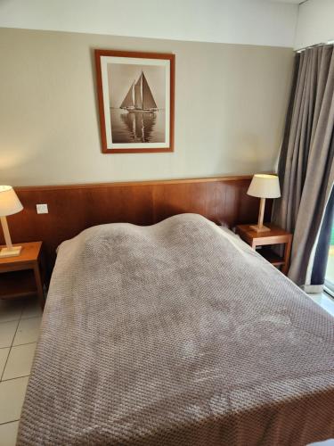 - une chambre avec un lit et une photo de bateau dans l'établissement Résidence les Grands Pins, à Carcans