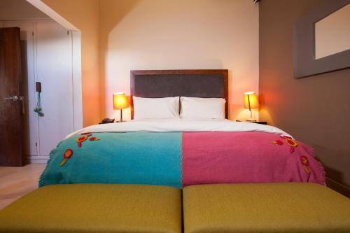 a bedroom with a bed with a colorful blanket on it at Hotel Huacalera in Huacalera
