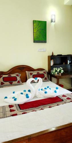 a bed with two swans made out of towels at Rasi Mount Rest in Mount Lavinia