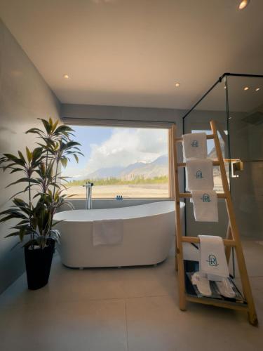 a bath tub in a bathroom with a window at Rivage Resort Skardu in Shigar