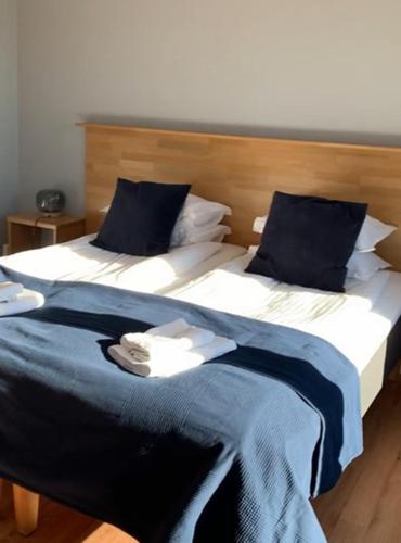 a large bed with blue and white sheets and pillows at Lygnerns Pensionat & Konferens in Sätila