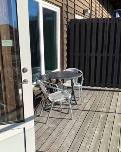 a patio with a table and chairs on a deck at Lygnerns Pensionat & Konferens in Sätila