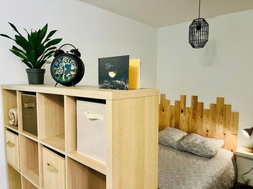 une chambre avec une étagère en bois avec une horloge dessus dans l'établissement Grand studio Ô Joie, à Auxerre