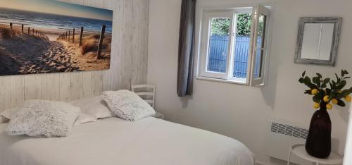 - une chambre avec un lit et une photo de la plage dans l'établissement Gîte avec Piscine et spa, à Éperlecques