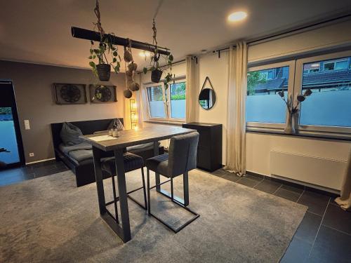 a dining room with a table and chairs and a couch at Cosy Bungalow-Apartment in ruhiger Toplage - nähe Düsseldorf in Krefeld