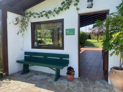 a green bench in front of a building with a door at Casa Benjamín in Oviedo