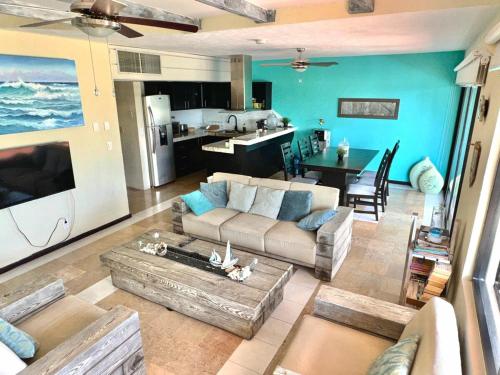a large living room with a couch and a kitchen at Azure Caribbean Beach Front in Puerto Aventuras