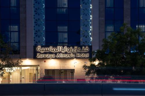 a sign on the front of a building at night at فندق زوايا الماسية الدائري in Al Madinah