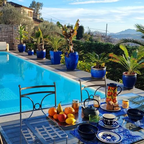 a table with fruit on it next to a swimming pool at Rare CHAMBRE D'HOTES avec Petit Déjeuner CANNES MOUGINS in Mougins