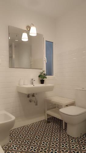 a bathroom with a sink and a toilet and a mirror at Sherryflat Terraza San Francisco in Jerez de la Frontera
