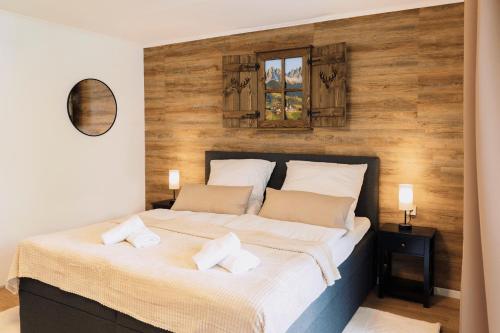a bedroom with a large bed with a wooden wall at Schwarzwald-Flair mit Naturblick & Balkon in Baiersbronn