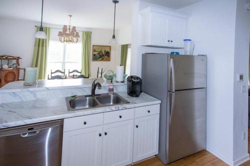 a kitchen with a sink and a stainless steel refrigerator at Chincoteague in Chincoteague