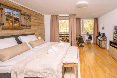 a large bedroom with two beds and a table at Schwarzwald-Flair mit Naturblick & Balkon in Baiersbronn