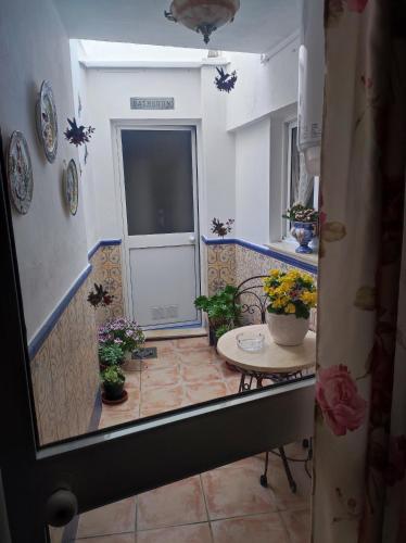 a room with a table and a door with potted plants at Casa Due Amori in Montilla