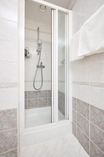 a shower with a glass door in a bathroom at Alma Apartments in Prague