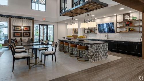 a kitchen with a bar and some chairs and tables at Luxury Apartments Near Airport in Austin