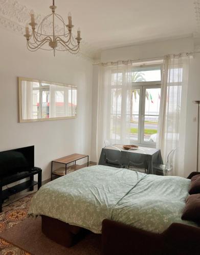 une chambre avec un lit, une table et des fenêtres dans l'établissement Studio Promenade, à Nice
