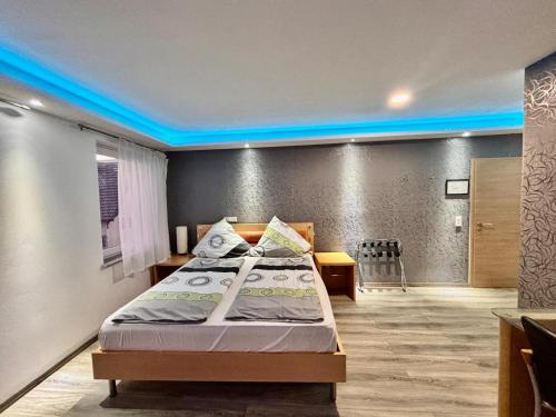 a bedroom with a bed with a blue lighting at CoBa Restaurant & Hotel in Baden-Baden