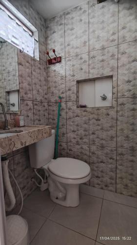 a small bathroom with a toilet and a sink at Casa Barbosa Paraty in Paraty