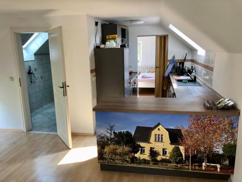 a kitchen and living room with a house on the counter at Storchennest - Ferienappartement mit Kamin, Sauna, Garten, E-Piano in Putlitz