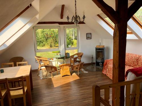 a living room with a table and chairs in a attic at Storchennest - Ferienappartement mit Kamin, Sauna, Garten, E-Piano in Putlitz