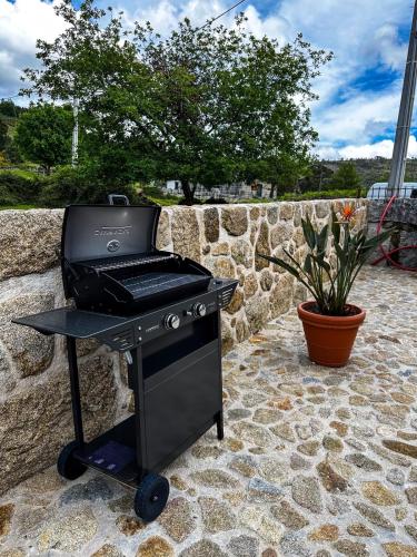 a barbecue grill sitting on a stone patio at Casa dos Manels in Arcos de Valdevez