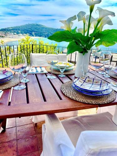 a wooden table with glasses and a vase with flowers at Relais Fontania in Gaeta