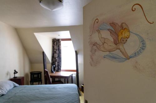 a bedroom with a painting of a fairy on the wall at Hotel De Pastorij in Leuven
