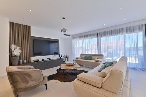 a living room with two couches and a flat screen tv at Villa Oasis in Trogir