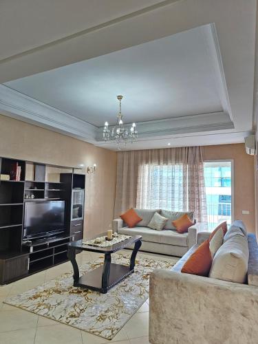 a living room with a couch and a tv at City Center Apartment in Tangier
