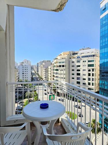 a table and chairs on a balcony with a view of a city at City Center Apartment in Tangier
