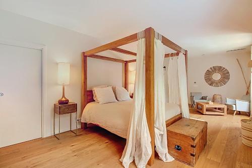 - une chambre avec un lit à baldaquin et du parquet dans l'établissement Superbe Mas Provençal rénové avec piscine, billard et climatisation à Paradou, à Paradou