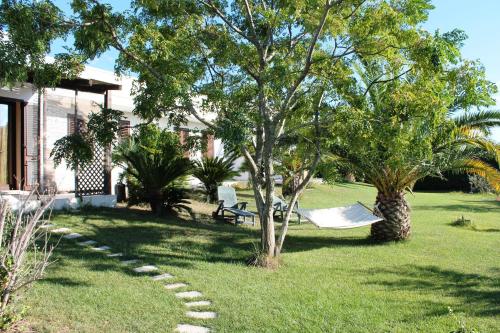 a hammock in a yard next to a house at Vecchio Ulivo in Vignacastrisi