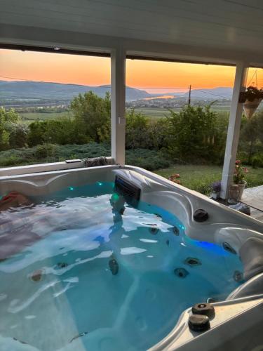 a jacuzzi tub with a view of the sunset at Szarvas Vendégház in Zebegény