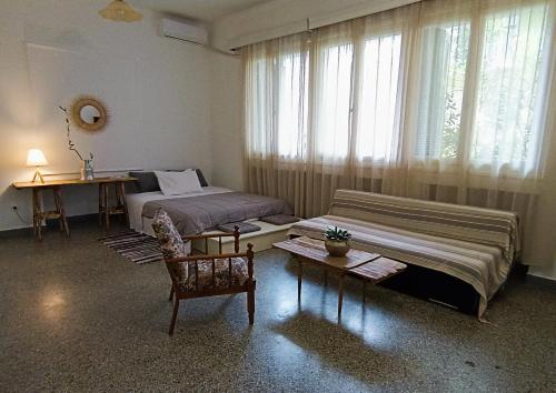 een slaapkamer met twee bedden en een tafel en een stoel bij The SPiTi Project 13 in Kavala