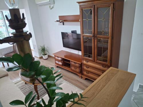 a living room with a tv and a wooden cabinet at Apartments Radoman in Ulcinj