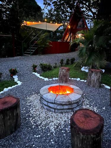 a fire pit in a yard with three logs at Betulio's Oasis in Fortuna