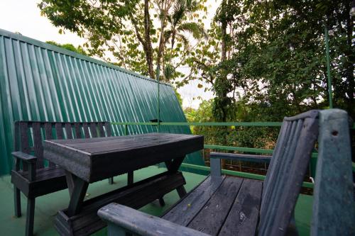 a wooden table and two benches sitting on a deck at Betulio's Oasis in Fortuna