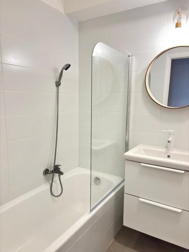 une salle de bain blanche avec une douche et un lavabo dans l'établissement Sea View Apartment 50 m to Beach FREE Parking, à Cagnes-sur-Mer