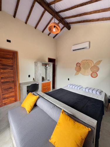a bedroom with a large bed with yellow pillows at Vila São Jorge in Barra Grande