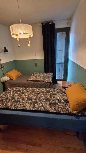 une chambre avec deux lits et une fenêtre dans l'établissement Maison Serra, à Collioure